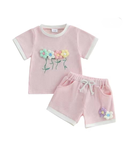 Children's pink outfit with floral designs on a white background