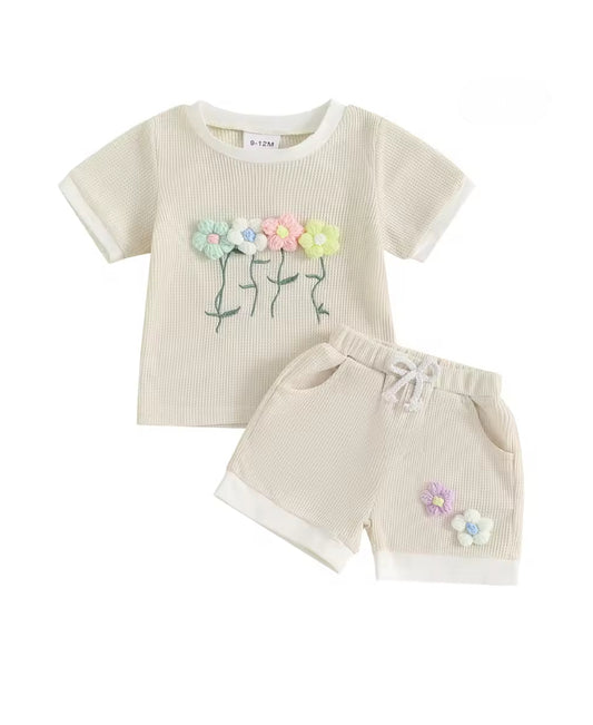 Children's outfit with t-shirt and shorts featuring floral designs on a white background