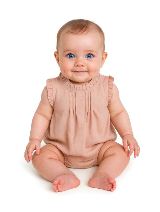 Baby wearing a beige sleeveless romper on a white background