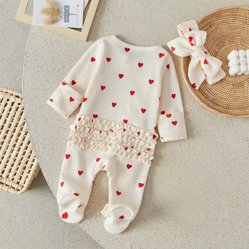 Baby outfit with heart patterns on a neutral background