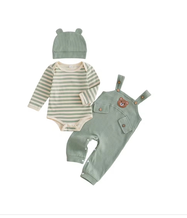 A three-piece baby clothing set laid out on a white background, featuring a sage green ribbed knit hat with bear ears, a cream and sage green striped long-sleeve bodysuit, and sage green corduroy-style overalls with a bear face patch on the chest.