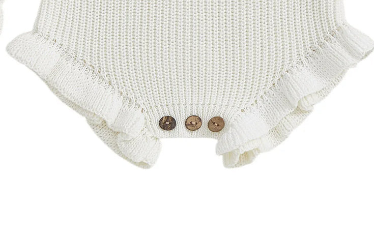 White knitted romper with ruffled details and buttons on a white background