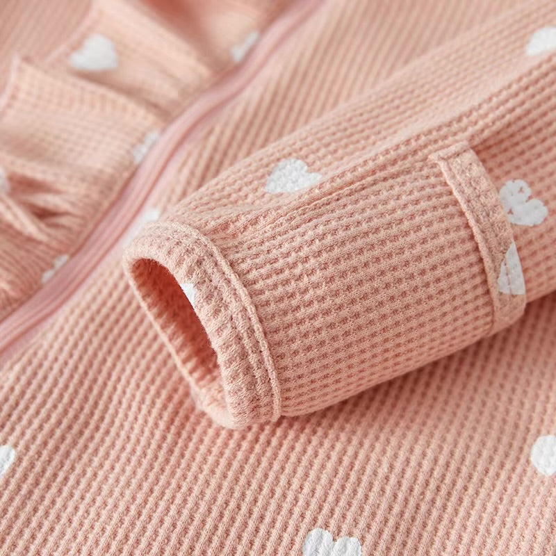 Close-up of pink textured fabric with white heart patterns