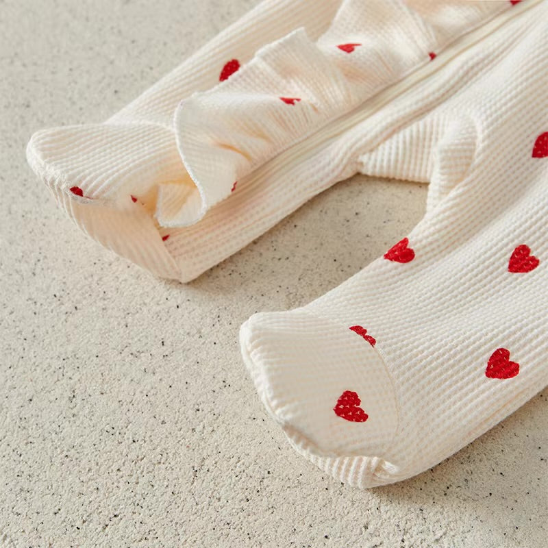 White socks with red heart patterns on a beige surface