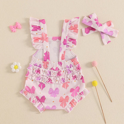 Children's floral romper with ruffles and matching headband on a beige background