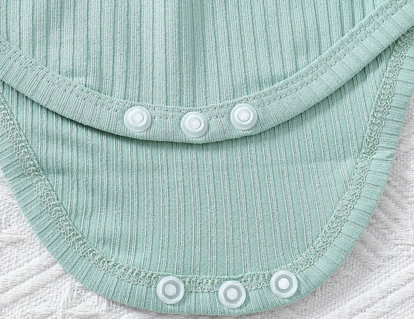 Close-up of a light blue fabric with buttons on a textured surface