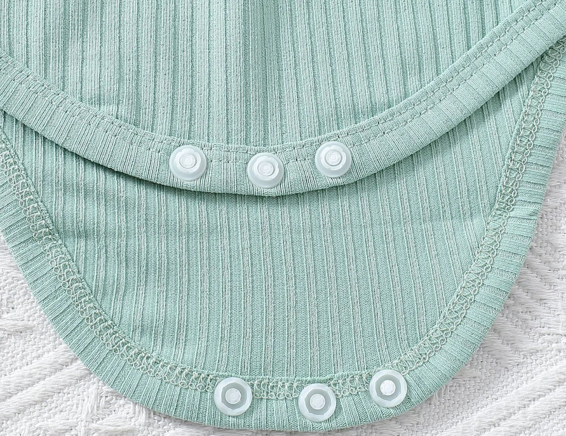 Close-up of a light blue fabric with buttons on a textured surface