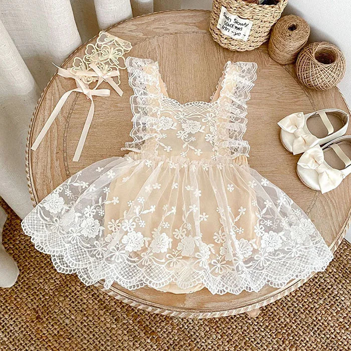 Lace dress on a wooden table with ribbons and shoes