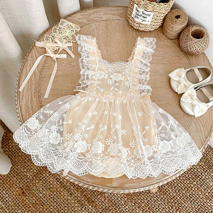 Lace dress on a wooden table with ribbons and shoes