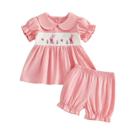 Pink baby dress with ruffled collar and matching bloomers on a white background