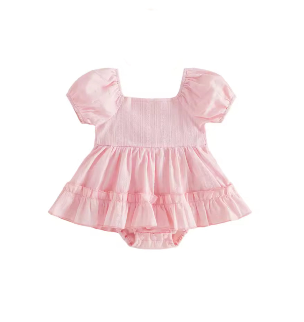 Pink baby dress with ruffled sleeves and layers on a white background