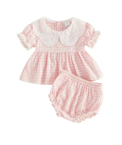 Pink checkered baby dress with white lace collar and matching bloomers on a white background
